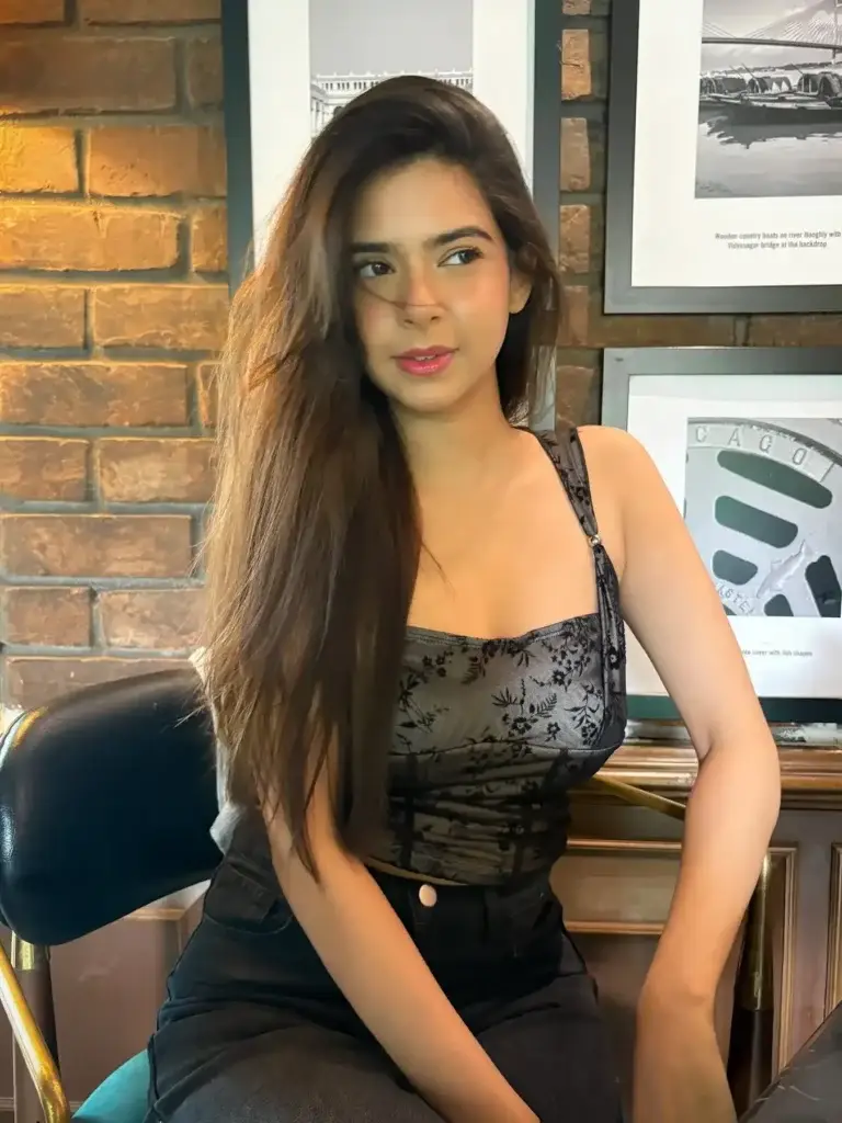 Gorgeous high-profile model Dubai, Esha, sitting confidently on a bed waiting to fulfill your deepest fantasies.